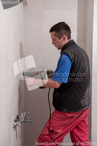 Image of construction worker drilling holes in the bathroom