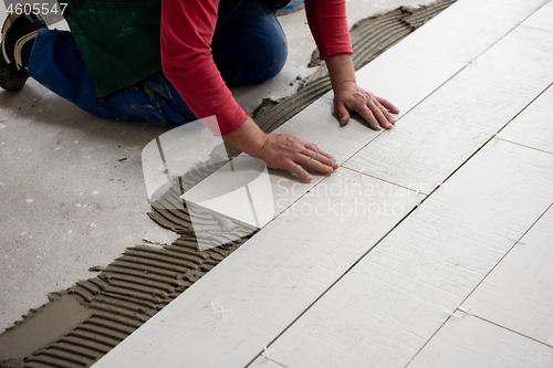 Image of worker installing the ceramic wood effect tiles on the floor