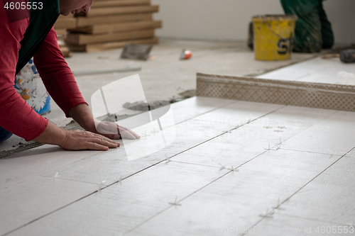 Image of worker installing the ceramic wood effect tiles on the floor