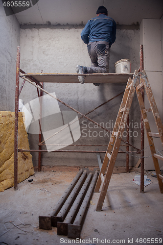 Image of construction worker plastering on gypsum ceiling