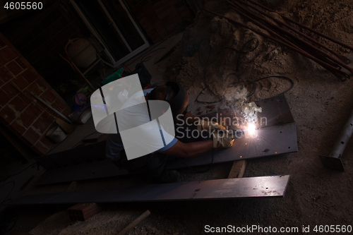 Image of welder with protective mask welding steel