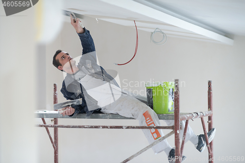 Image of construction worker plastering on gypsum ceiling