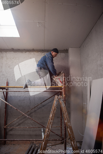 Image of construction worker plastering on gypsum ceiling