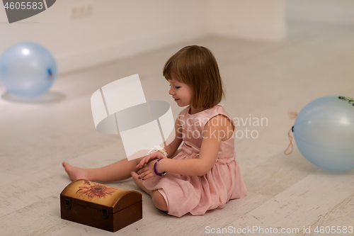 Image of little girl enjoying while playing with mother\'s jewelry