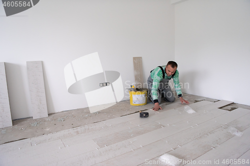 Image of worker installing the ceramic wood effect tiles on the floor