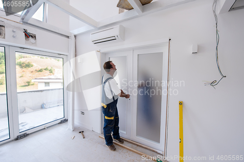 Image of carpenters installing glass door with a wooden frame