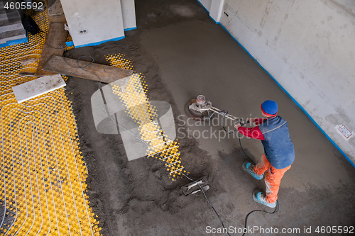 Image of worker performing and polishing sand and cement screed floor