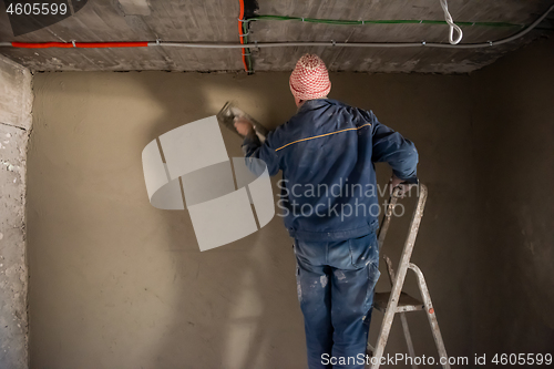 Image of Worker plastering the wall by concrete