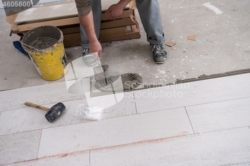 Image of worker installing the ceramic wood effect tiles on the floor