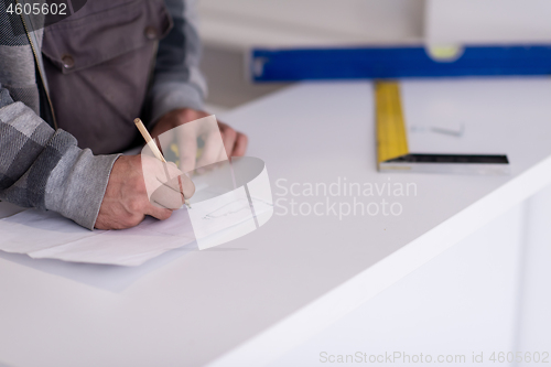 Image of the worker writing the measures