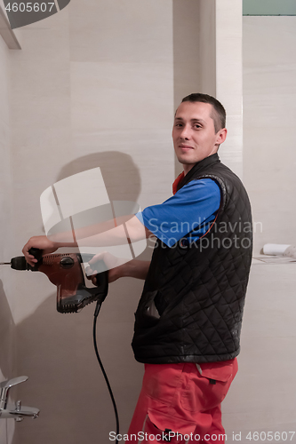 Image of construction worker drilling holes in the bathroom