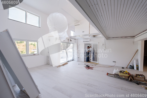 Image of carpenters installing glass door with a wooden frame