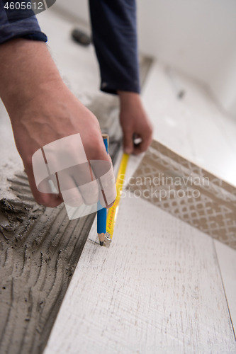 Image of worker installing the ceramic wood effect tiles on the floor