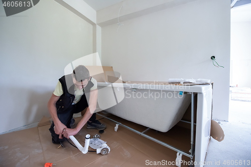 Image of professional plumber working in a bathroom