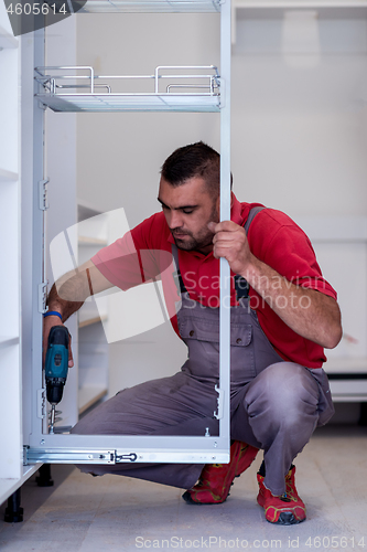 Image of worker installing a new kitchen