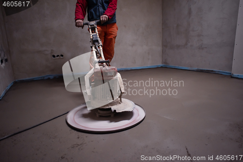 Image of worker performing and polishing sand and cement screed floor