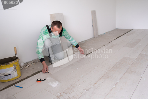 Image of worker installing the ceramic wood effect tiles on the floor