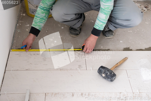 Image of worker installing the ceramic wood effect tiles on the floor