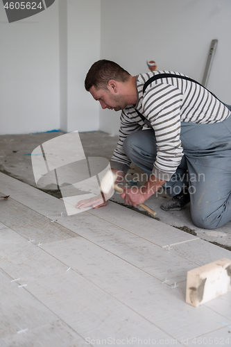 Image of worker installing the ceramic wood effect tiles on the floor