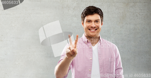 Image of happy man showing two fingers or peace hand sign