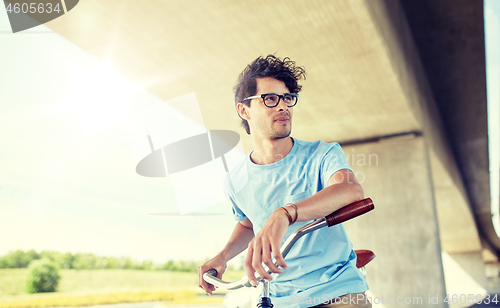 Image of young hipster man riding fixed gear bike