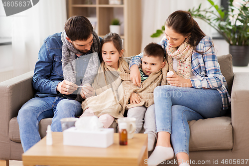 Image of family with ill children having fever at home