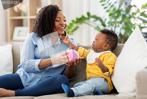 Image of mother and baby playing with ball at home