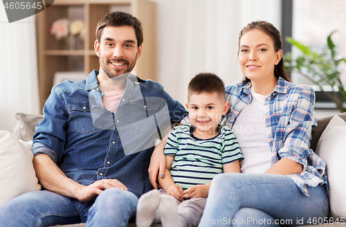 Image of portrait of happy family sitting on sofa at home