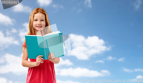 Image of smiling red haired girl reading book over sky