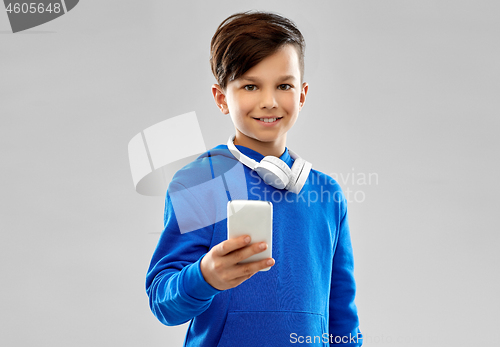 Image of smiling boy in blue hoodie using smartphone