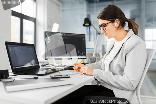 Image of businesswoman with notebook working at office