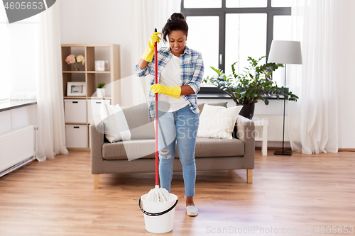 Image of african woman or housewife cleaning floor at home