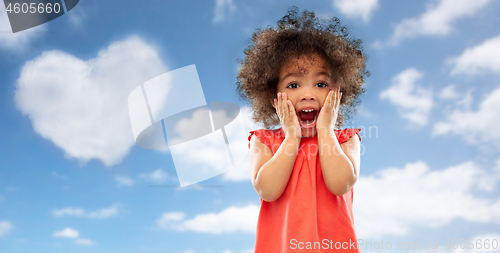 Image of surprised little african american girl over sky