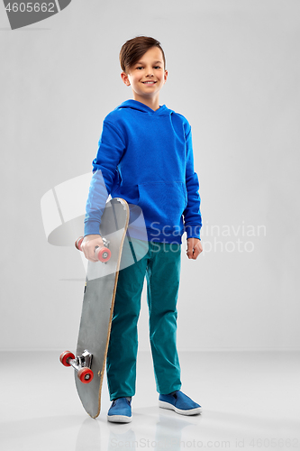 Image of smiling boy in blue hoodie with skateboard