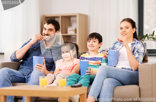 Image of happy family with popcorn watching tv at home