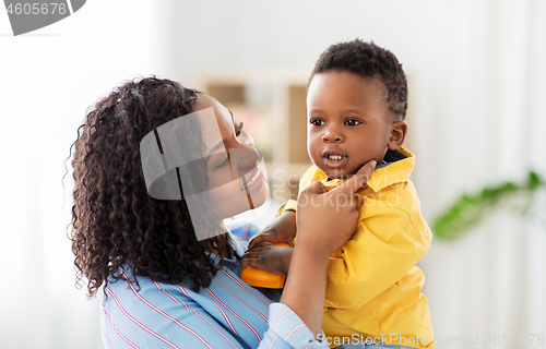 Image of happy african american mother with baby at home