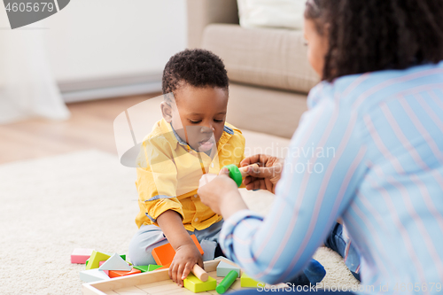 Image of mother and baby playing with toy blocks at home