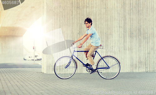 Image of young hipster man riding fixed gear bike