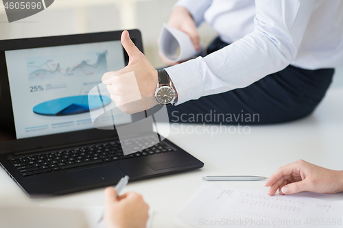 Image of businessman showing thumbs up at office