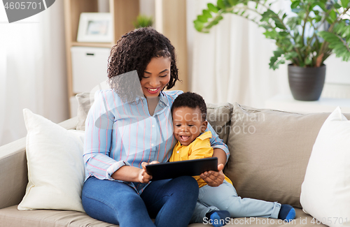 Image of mother using tablet pc with baby son at home