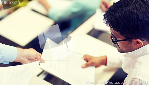 Image of teacher giving exam test to student at lecture