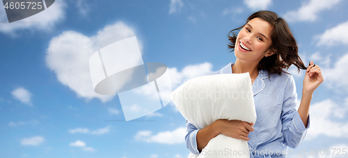 Image of happy young woman in pajama with pillow over sky