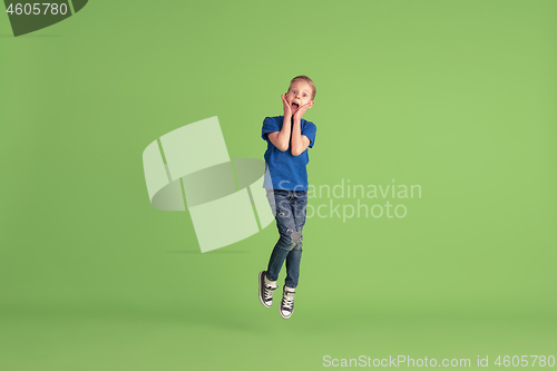 Image of Happy boy playing and having fun on green studio background, emotions