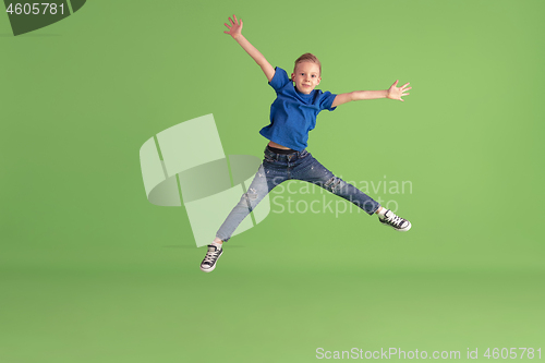 Image of Happy boy playing and having fun on green studio background, emotions