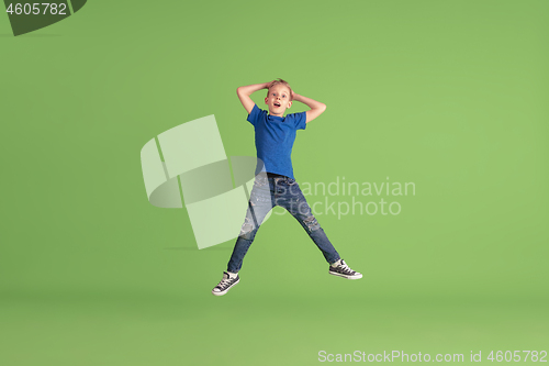 Image of Happy boy playing and having fun on green studio background, emotions