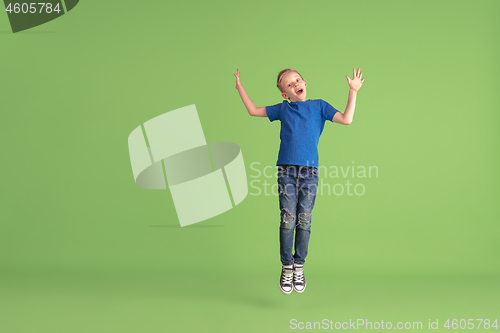 Image of Happy boy playing and having fun on green studio background, emotions