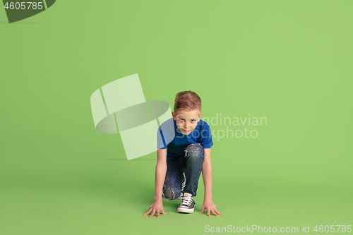 Image of Happy boy playing and having fun on green studio background, emotions