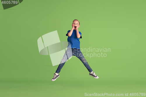 Image of Happy boy playing and having fun on green studio background, emotions