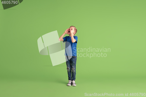 Image of Happy boy playing and having fun on green studio background, emotions