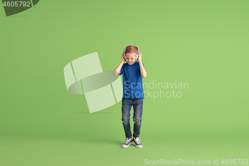 Image of Happy boy playing and having fun on green studio background, emotions